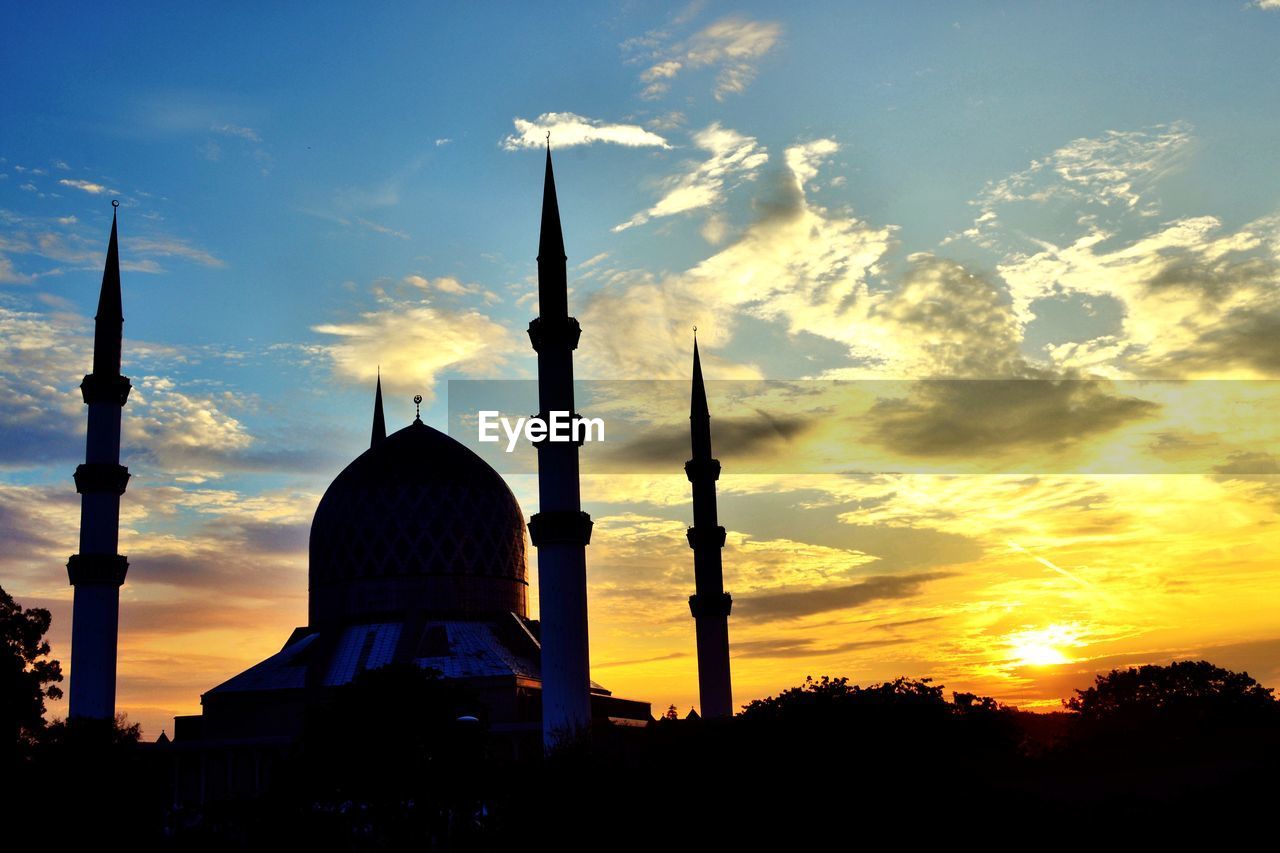 SILHOUETTE OF MOSQUE AGAINST SKY DURING SUNSET