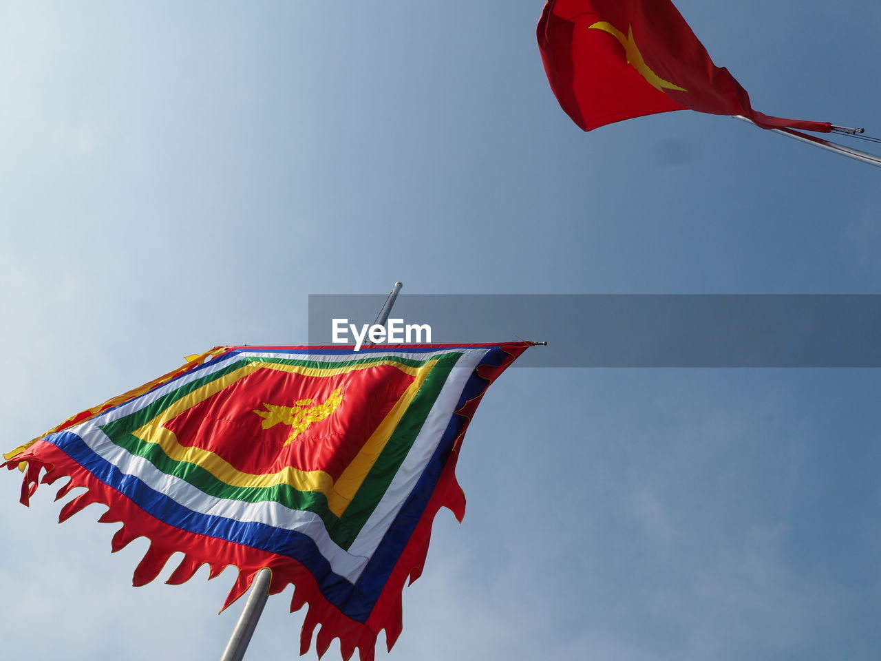 Low angle view of flags outside ngoc son temple against blue sky