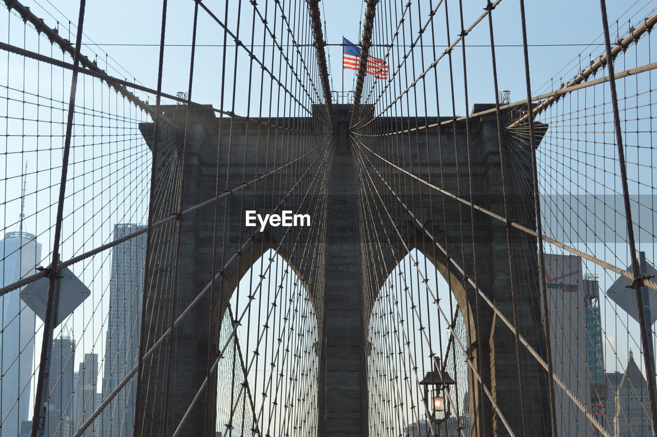 Low angle view of brooklyn bridge against sky in new york city.