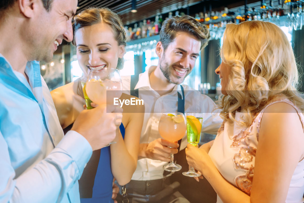 Friends toasting drinks at bar