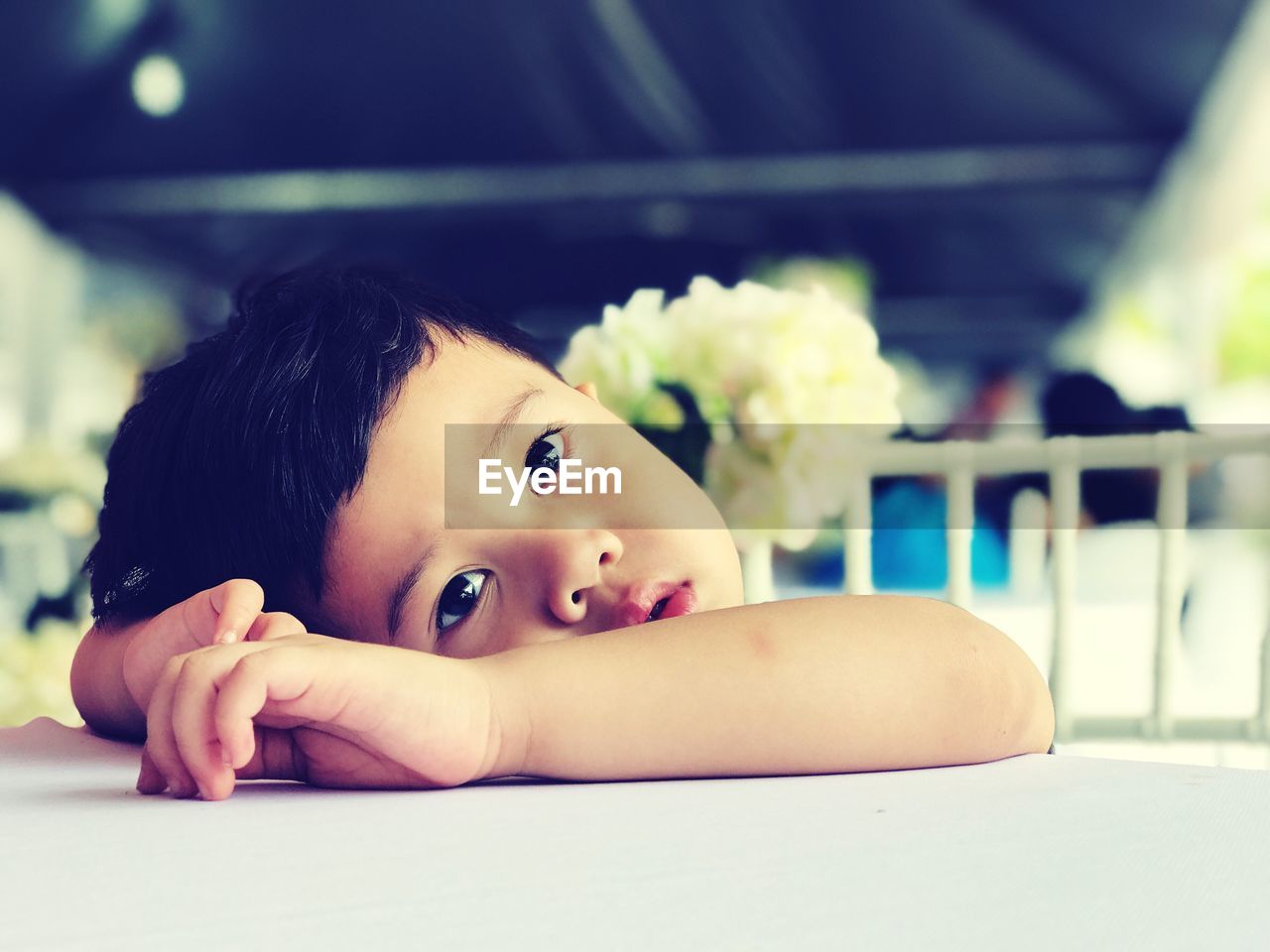 Close-up of thoughtful boy looking away while leaning head on table