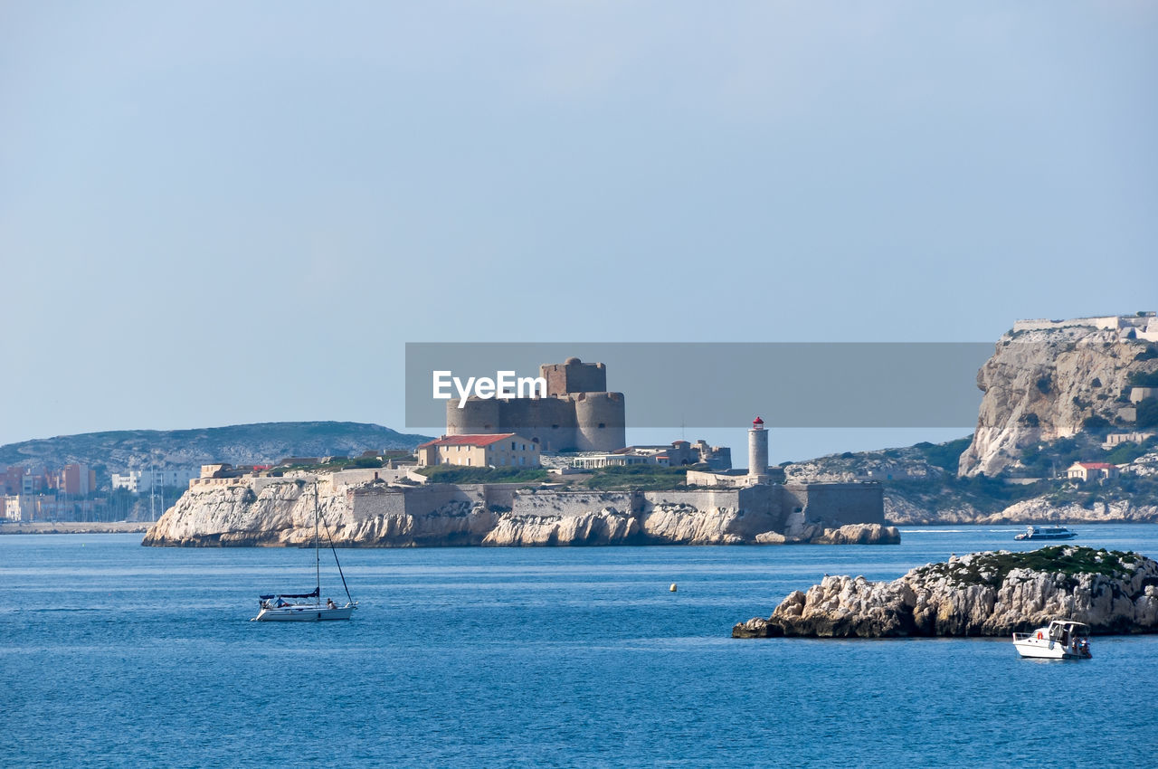 Scenic view of sea and ruins against clear sky