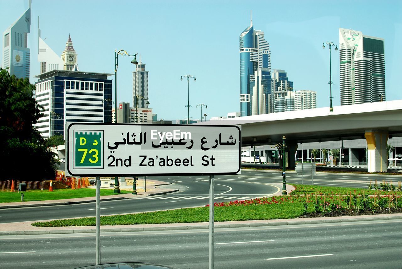 ROAD SIGN BY BUILDINGS AGAINST SKY