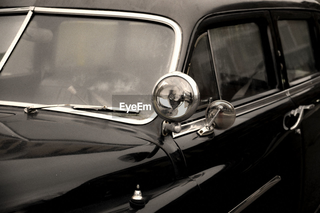 CLOSE-UP OF VINTAGE CAR ON SIDE-VIEW MIRROR