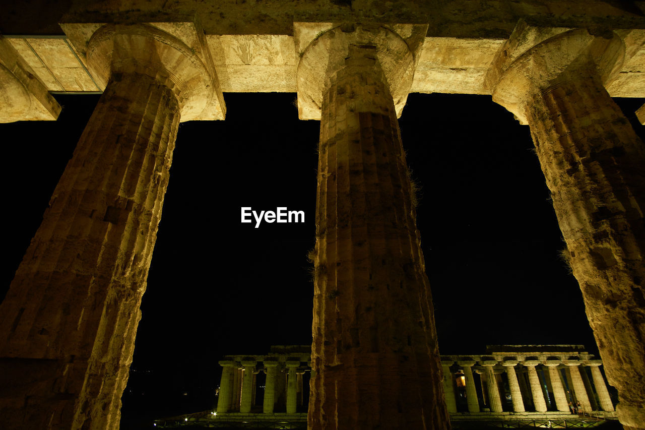 Low angle view of columns at historical building during night