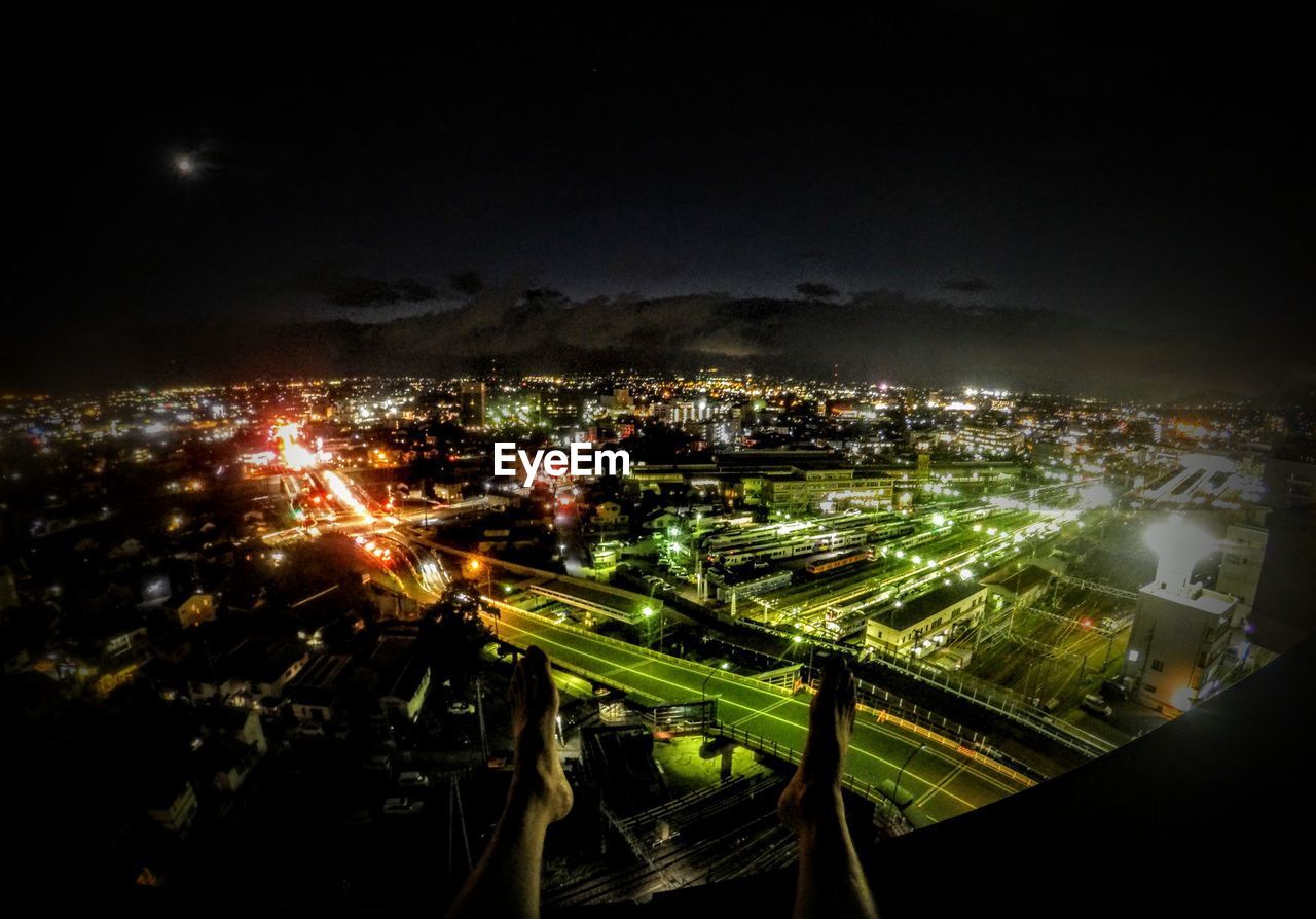 HIGH ANGLE VIEW OF ILLUMINATED CITYSCAPE AGAINST SKY