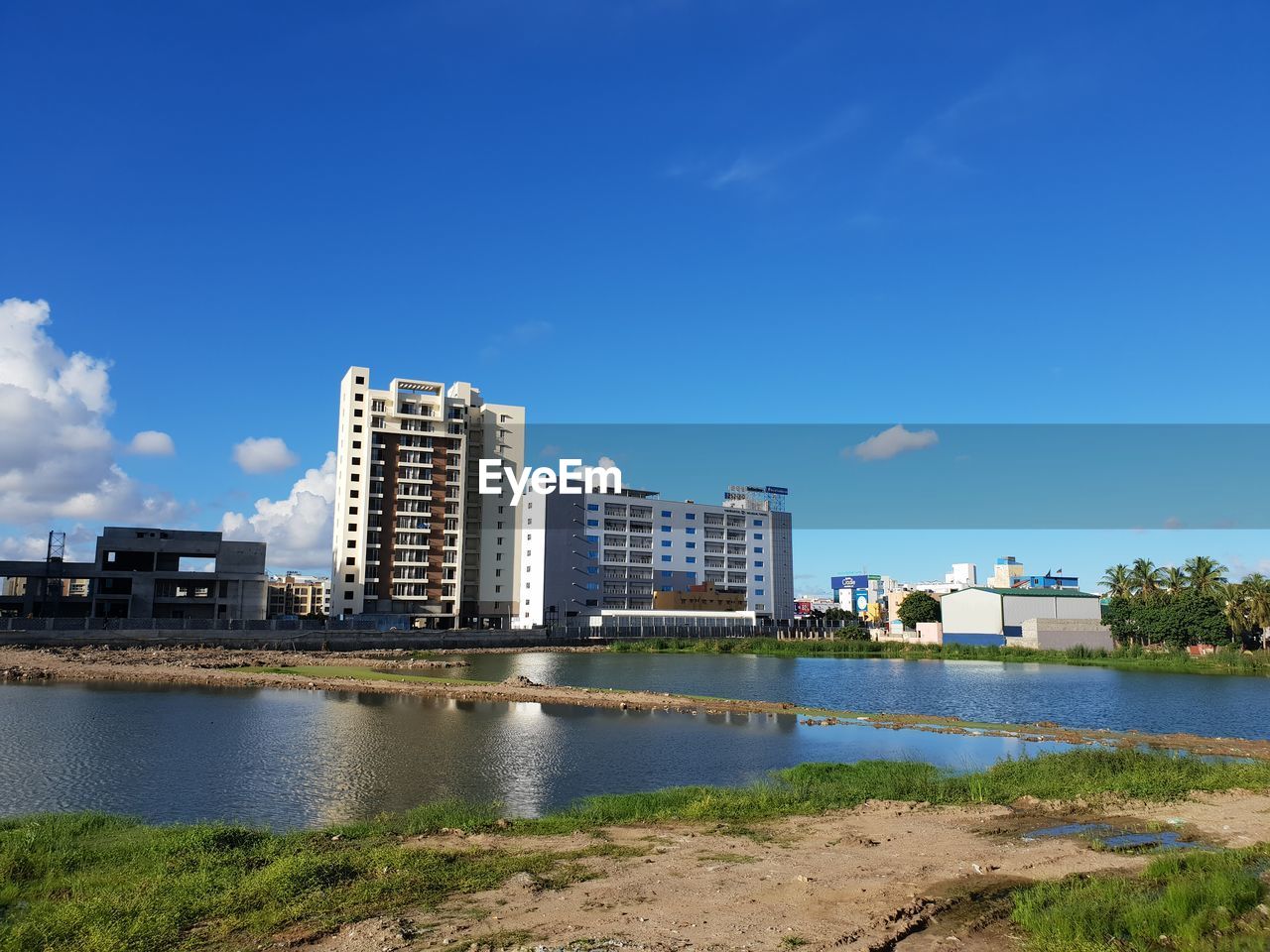 BUILDINGS BY RIVER AGAINST SKY