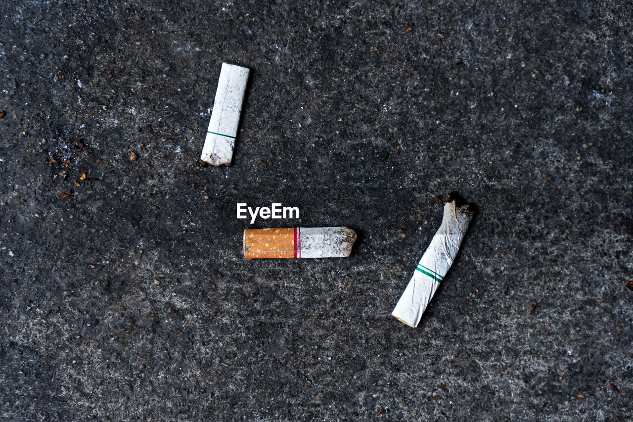 High angle view of cigarette butts on road