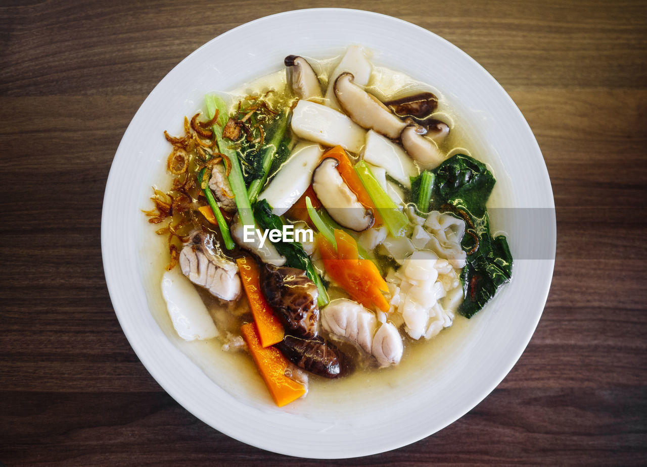 Dish of asian flat kuay tiao with spinach carrot mushrooms