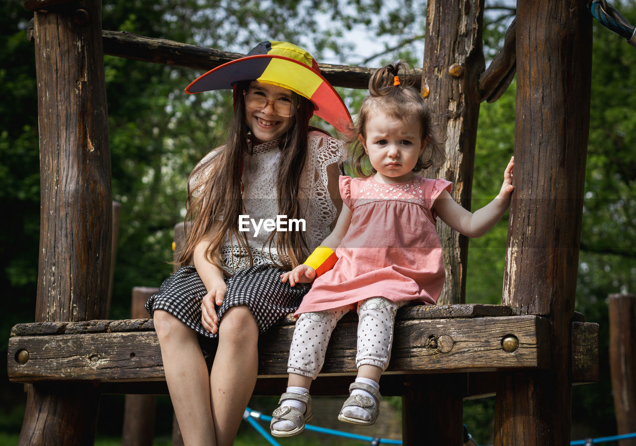 Portrait of two girls in a belgian flag hat in the park.