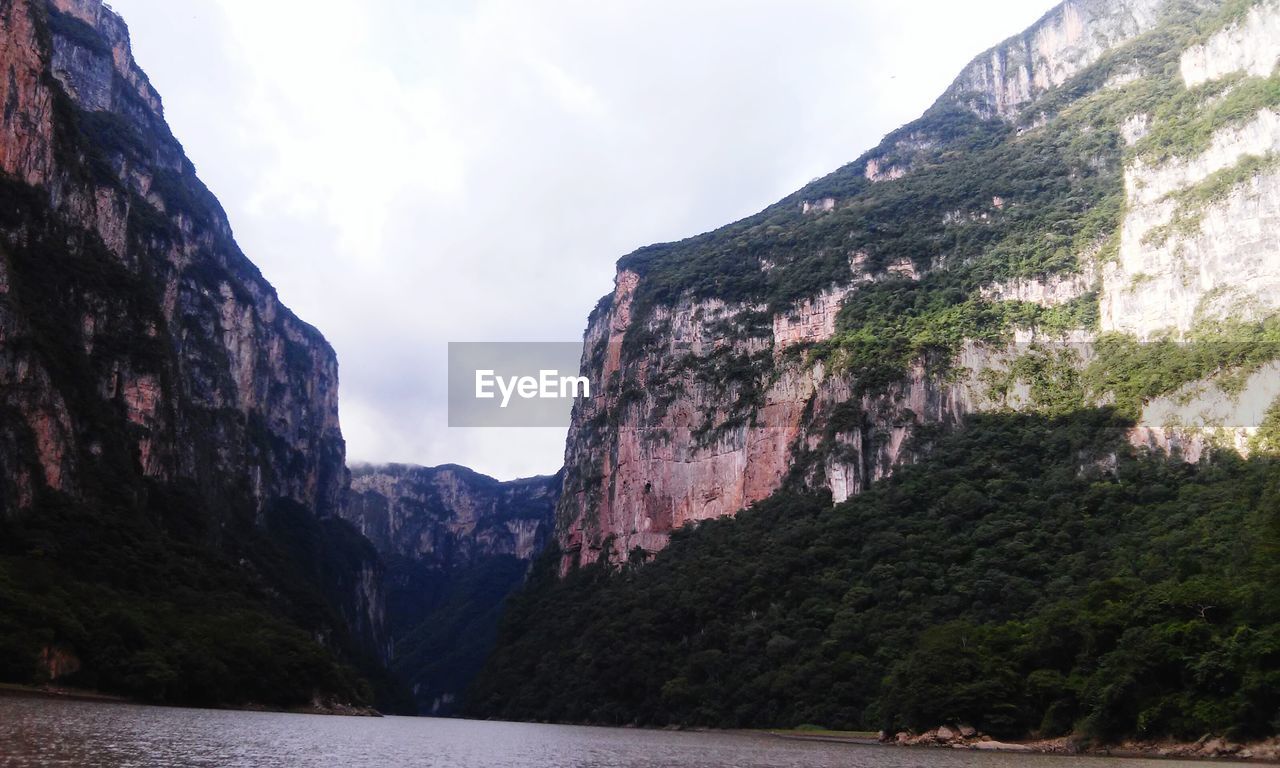 Scenic view of rocky mountains against cloudy sky