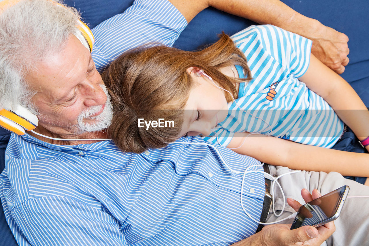 Grandfather and granddaughter listening music