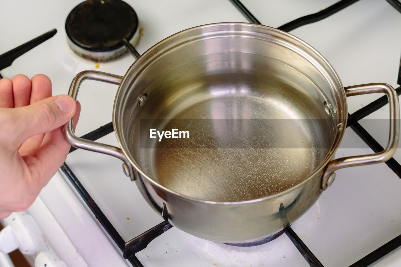 HIGH ANGLE VIEW OF PERSON PREPARING TEA IN KITCHEN