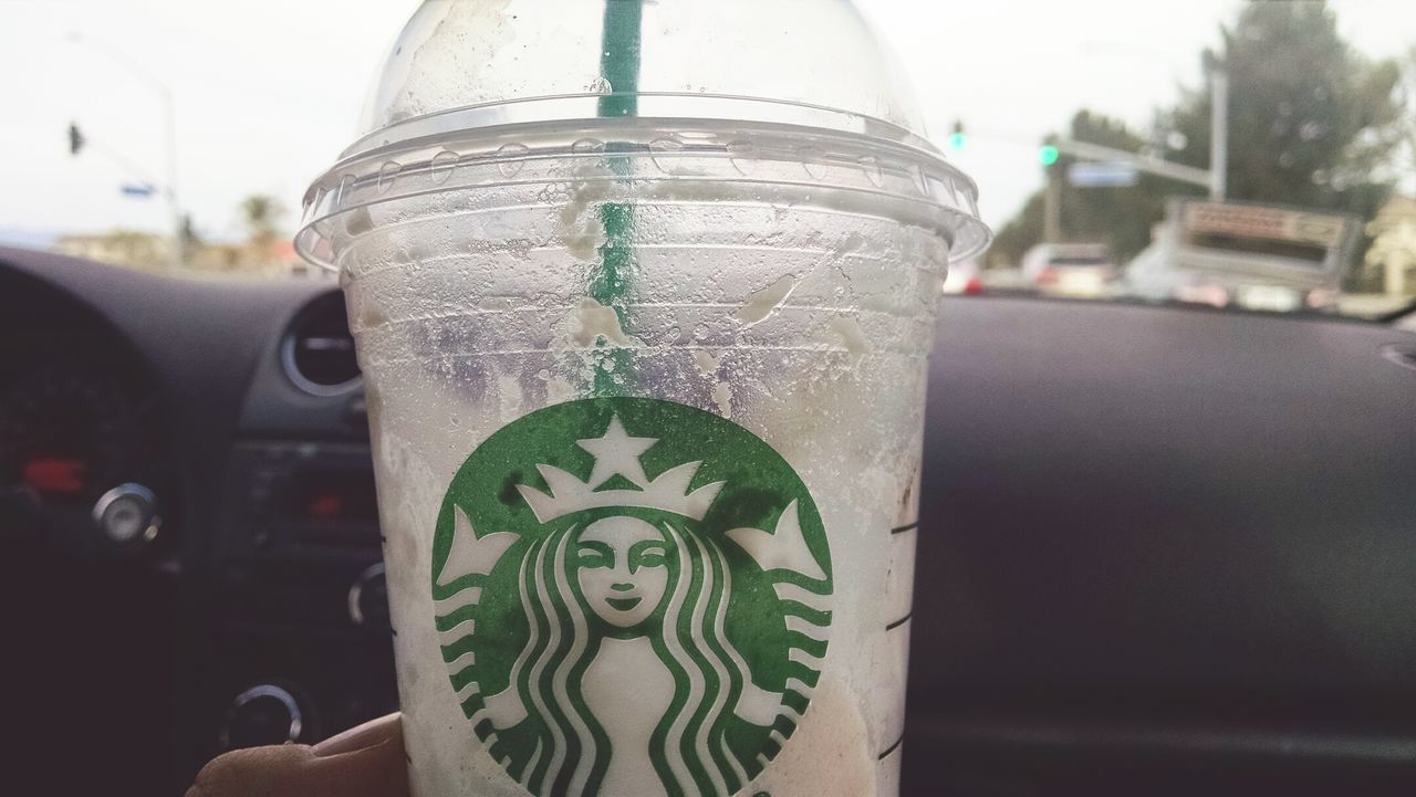 CLOSE-UP OF DRINK IN CAR OUTDOORS