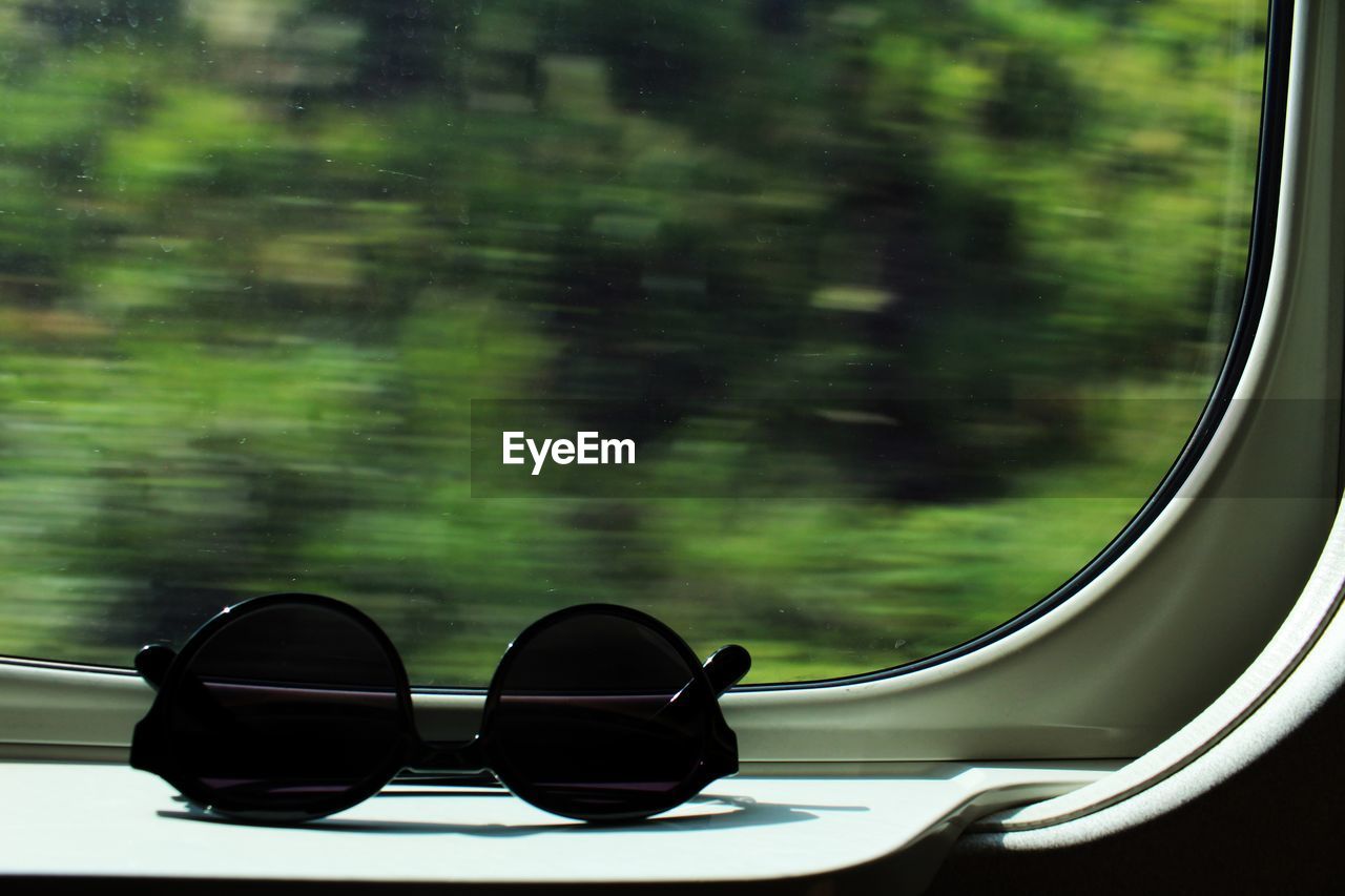 Close-up of sunglasses on moving train window