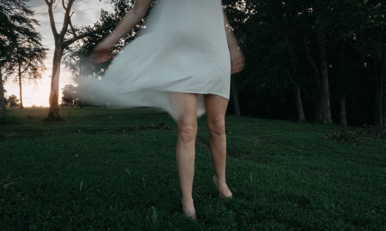 Low section of woman standing on tree trunk