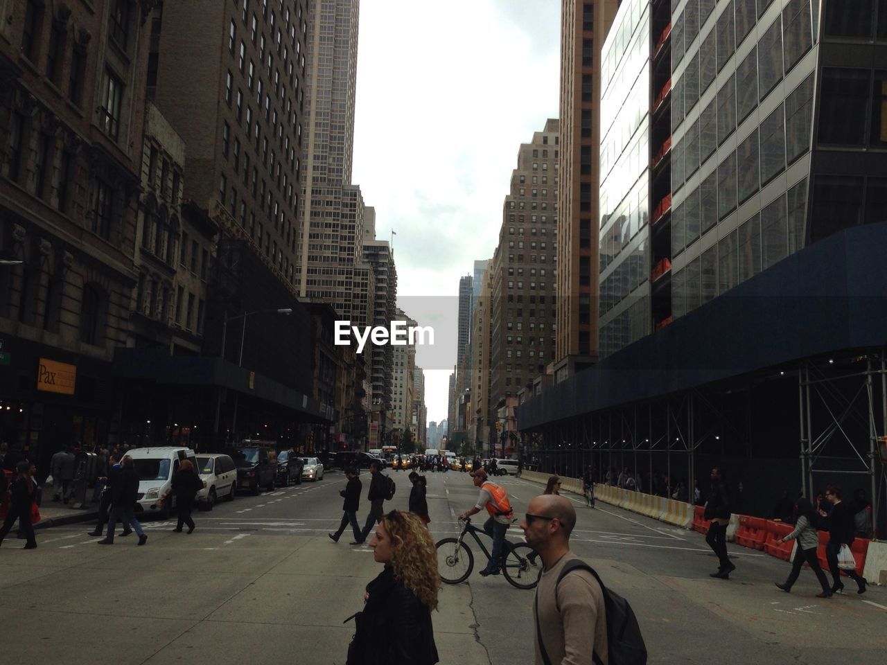 People on city street amidst buildings against sky