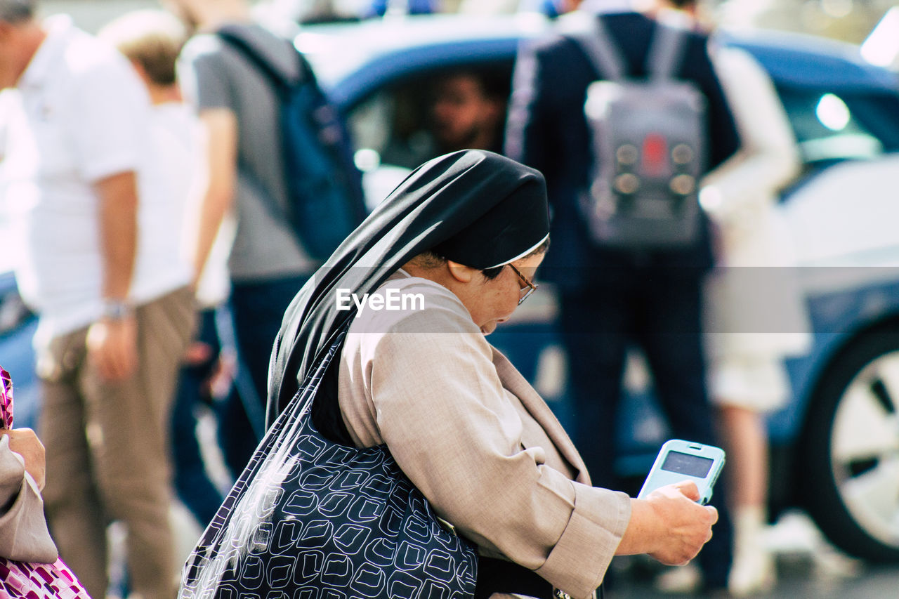 LOW ANGLE VIEW OF MOBILE PHONE ON CITY