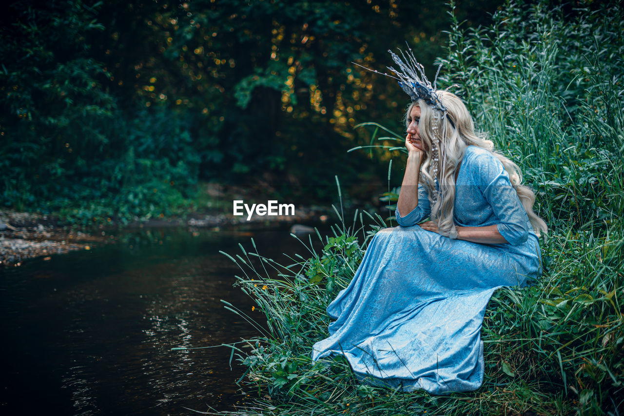 Portrait of young woman standing in forest