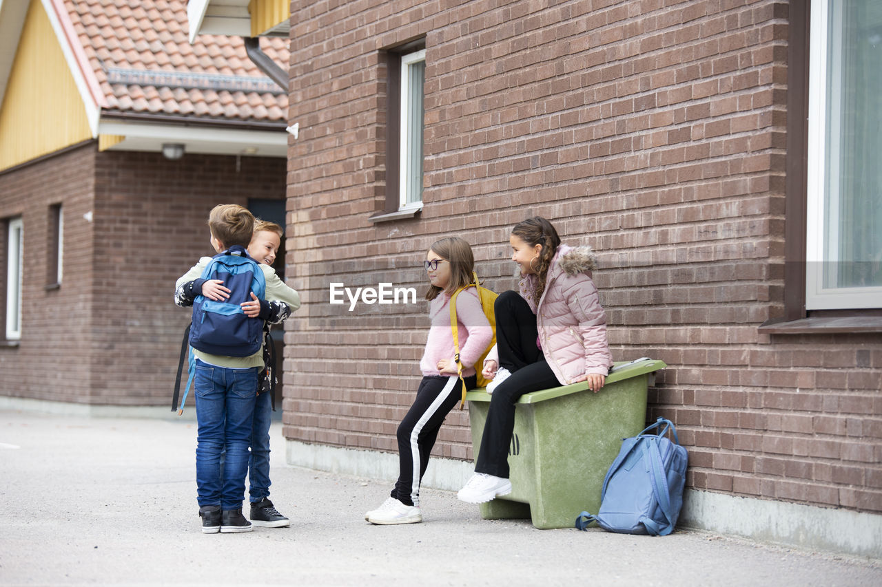 Smiling children in front of school