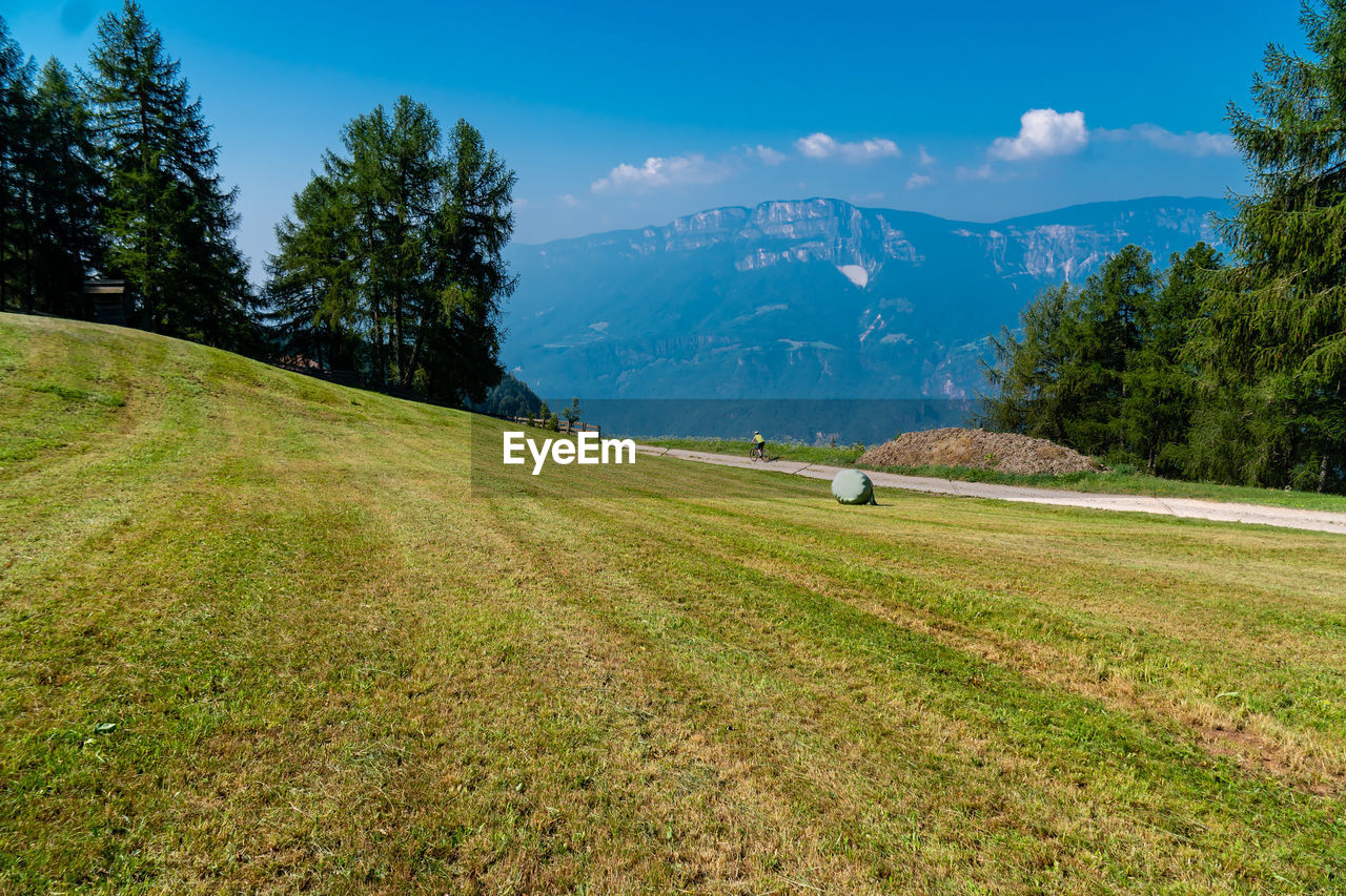 SCENIC VIEW OF FIELD BY MOUNTAINS AGAINST SKY