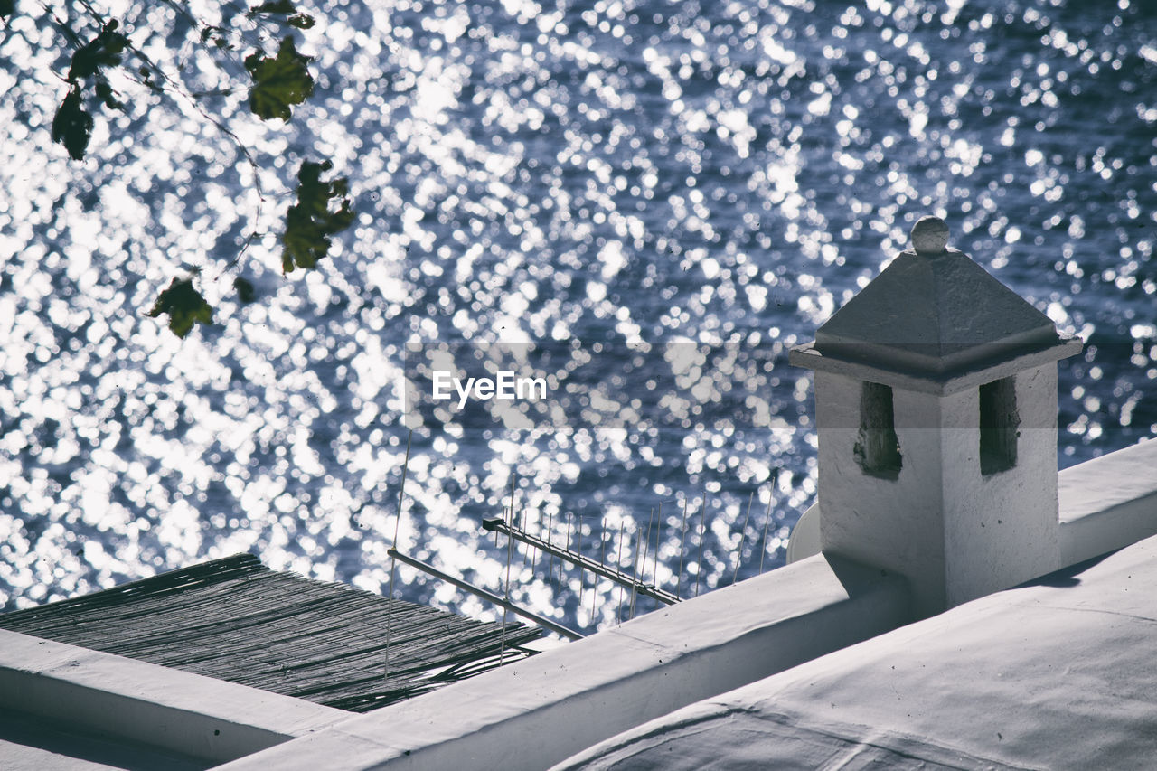 High angle view of house roof sea during sunny day