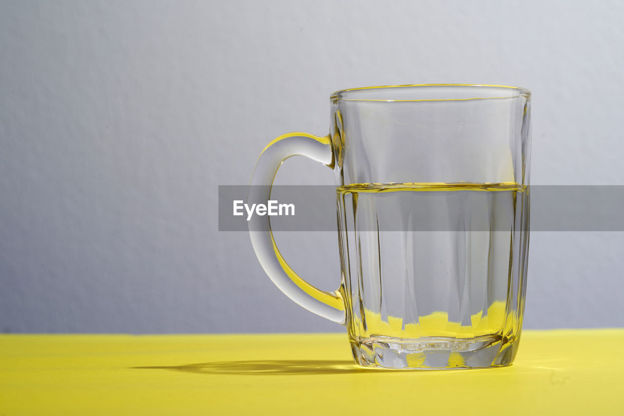 Glass of water on the yellow background