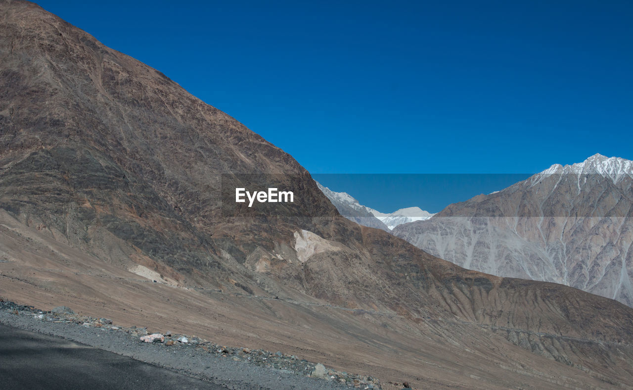 Scenic view of mountains against clear blue sky