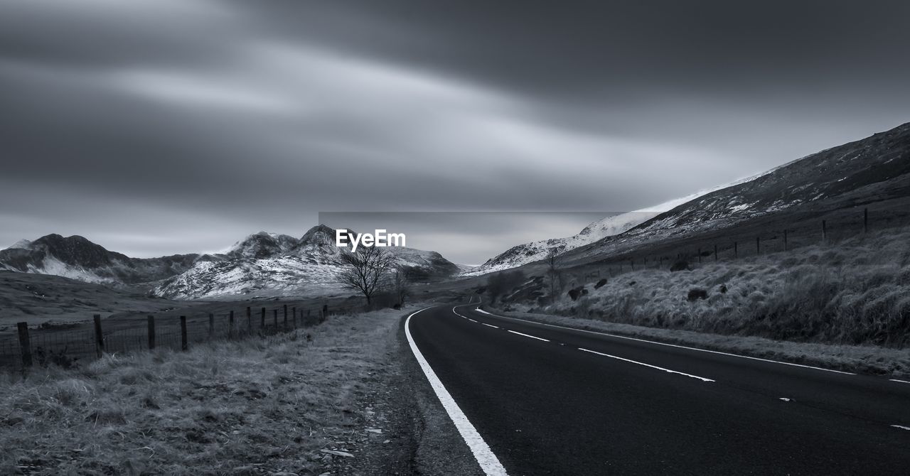 Empty road along countryside landscape