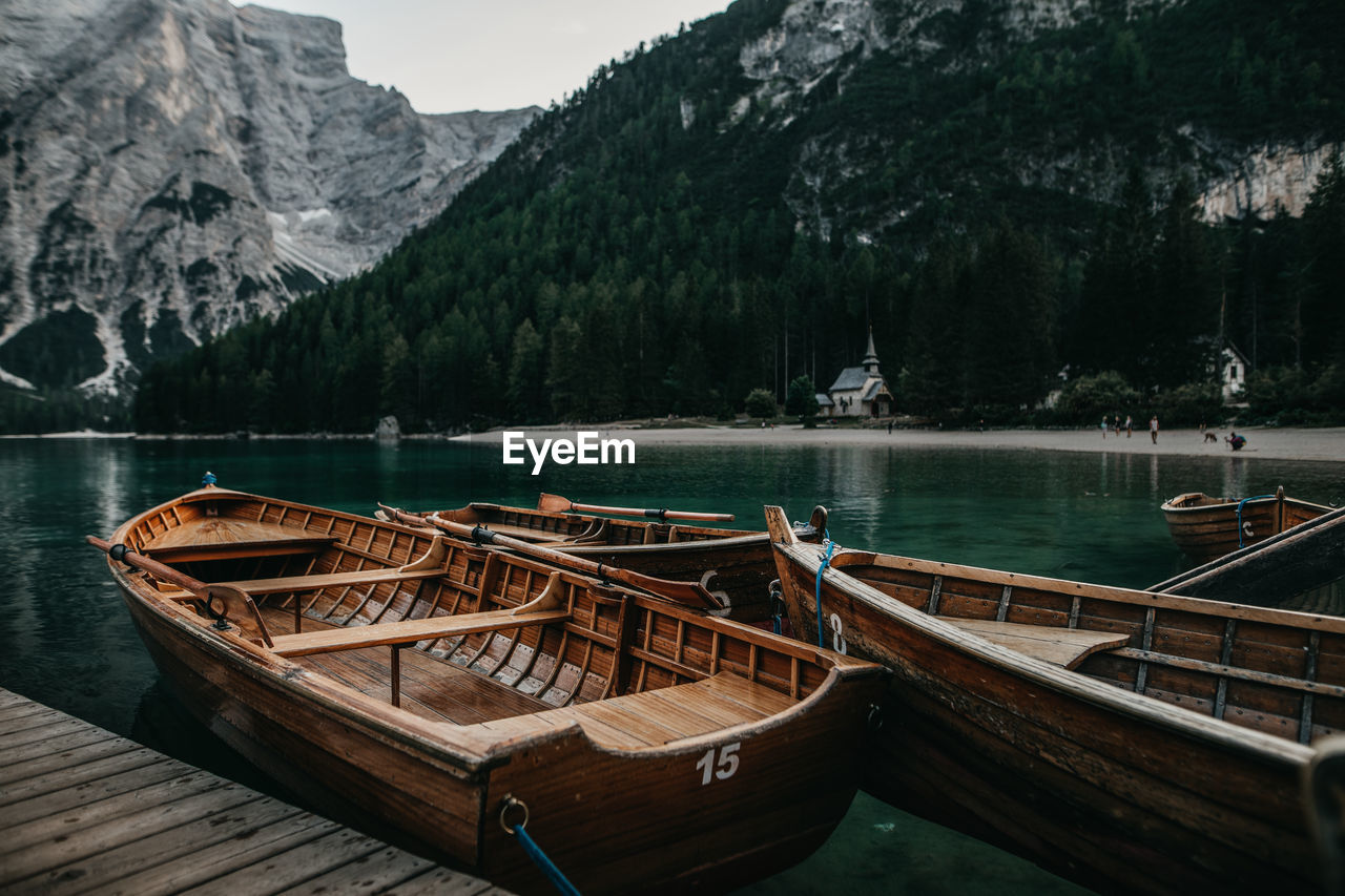 Boats moored on lake against mountains