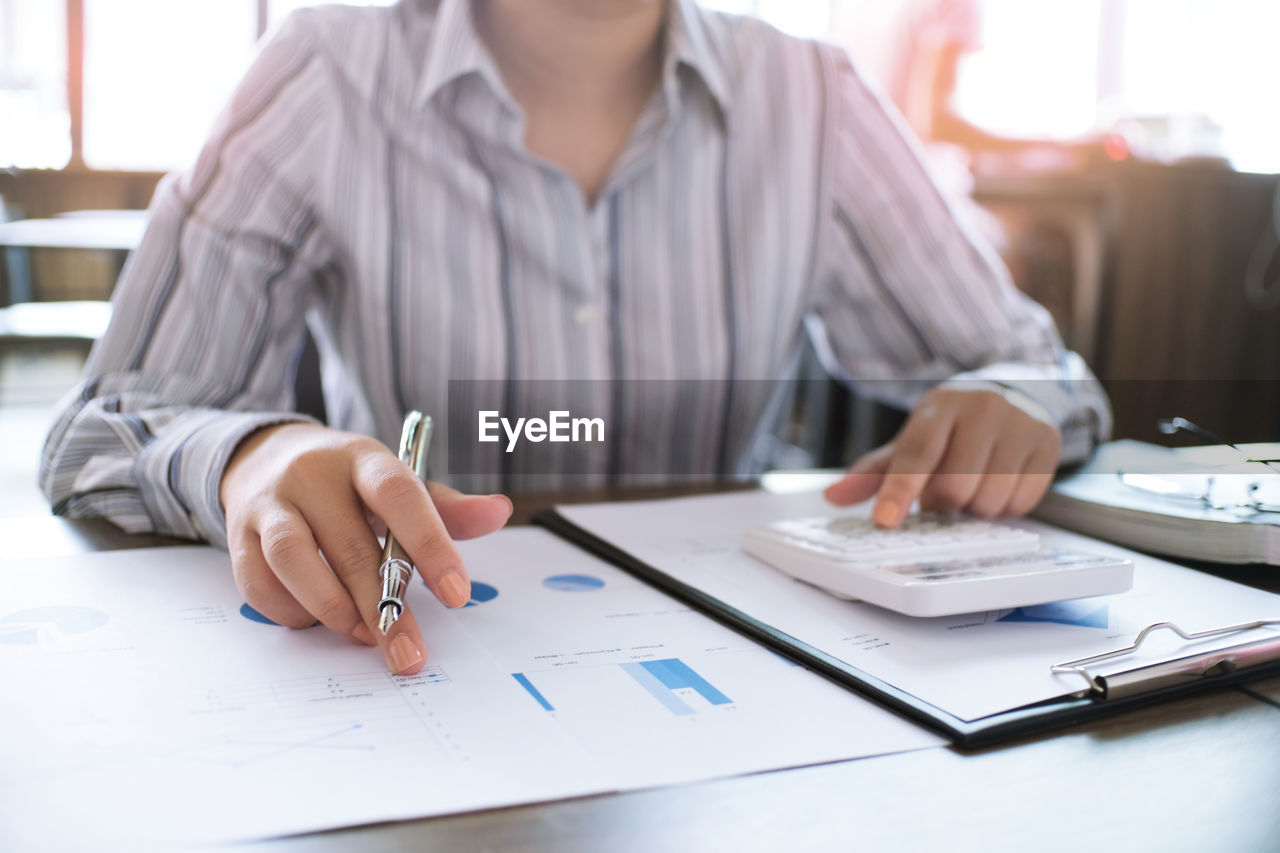 Close-up of businesswoman using calculator