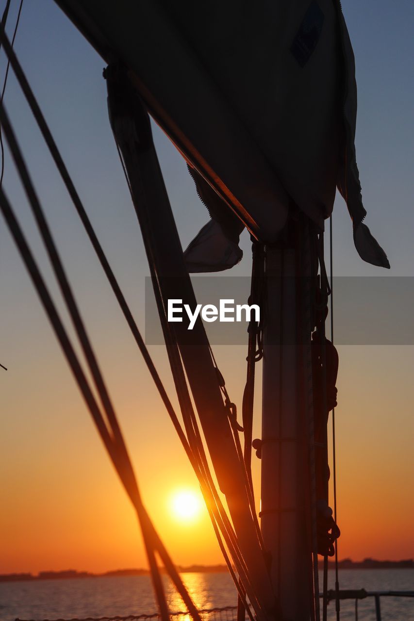 SILHOUETTE OF SAILBOAT AT SUNSET