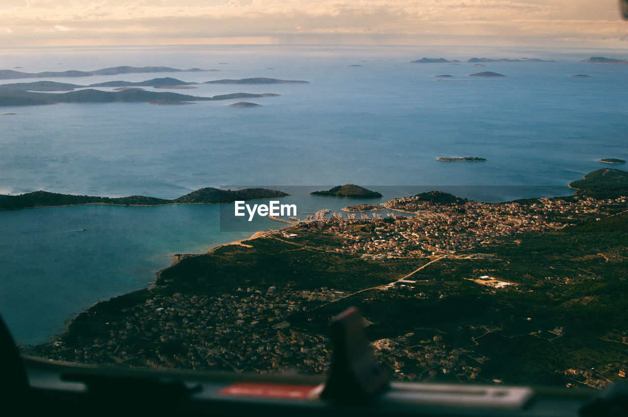 Aerial view of landscape by sea during sunset