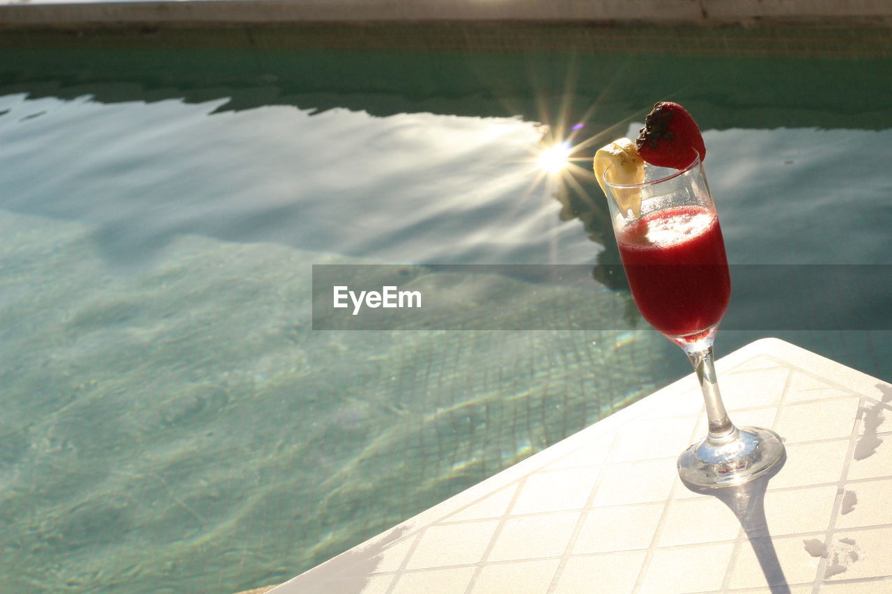 Close-up of drink by swimming pool