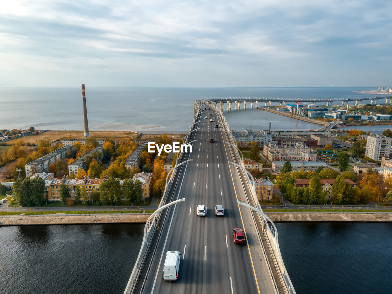 Aerial photo of cars driving on multilane highway. elevated bridge with high speed road above houses