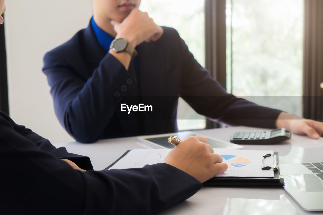 Business coworkers discussing at desk in office