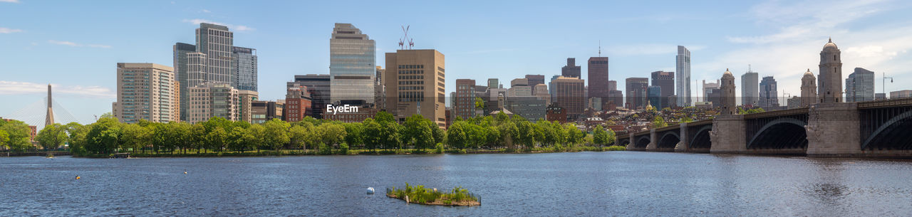 Scenic view of river by buildings against sky in city