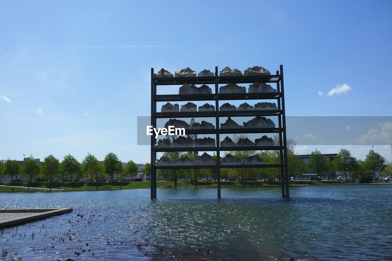 INFORMATION SIGN ON LAKE AGAINST SKY