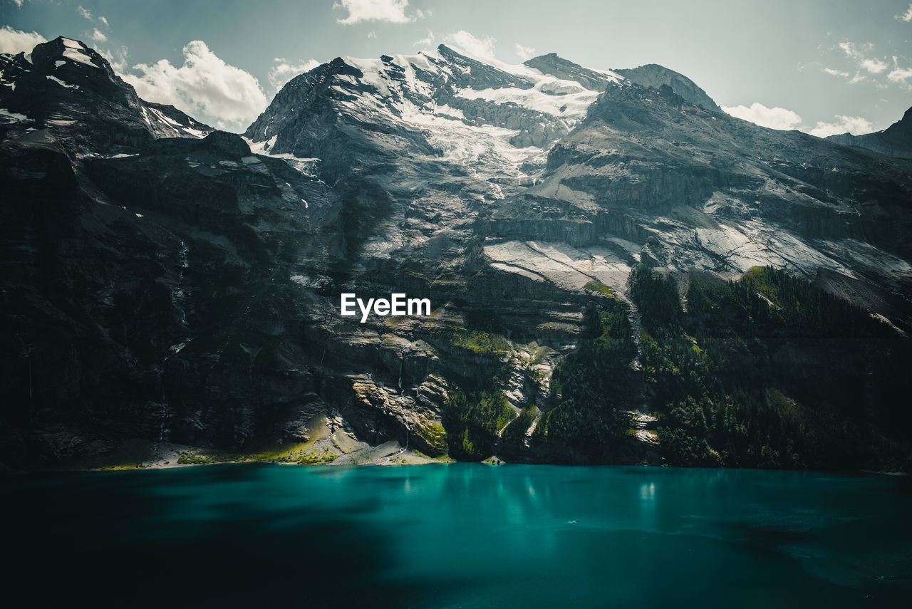 Scenic view of lake by mountains against sky