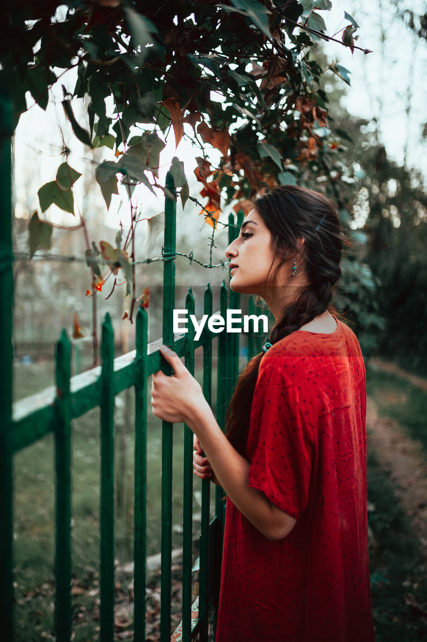 Girl leaning on fence on rural property