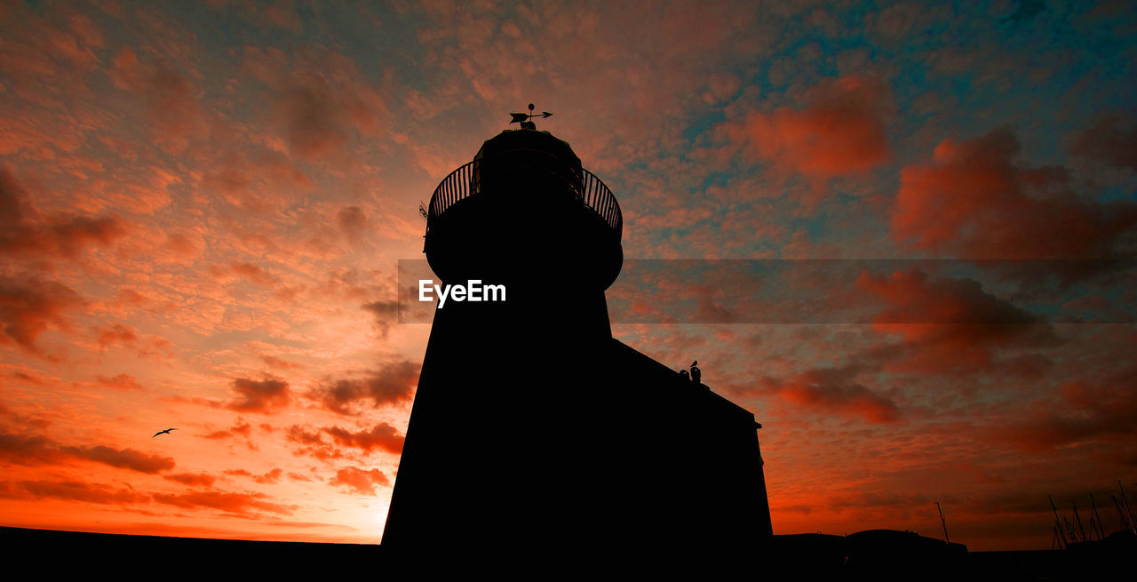 Low angle view of silhouette tower against sky during sunset