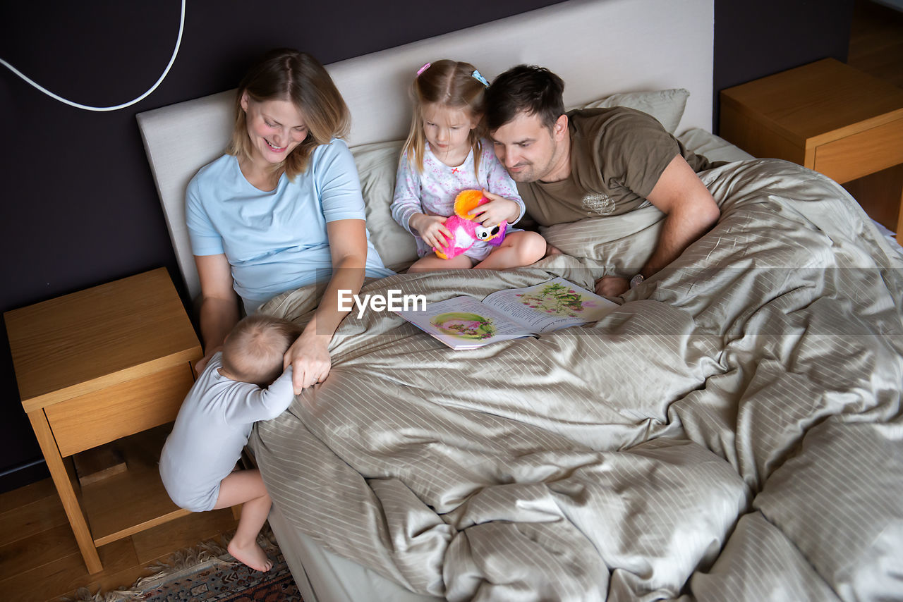 High angle view of parents with children on bed at home