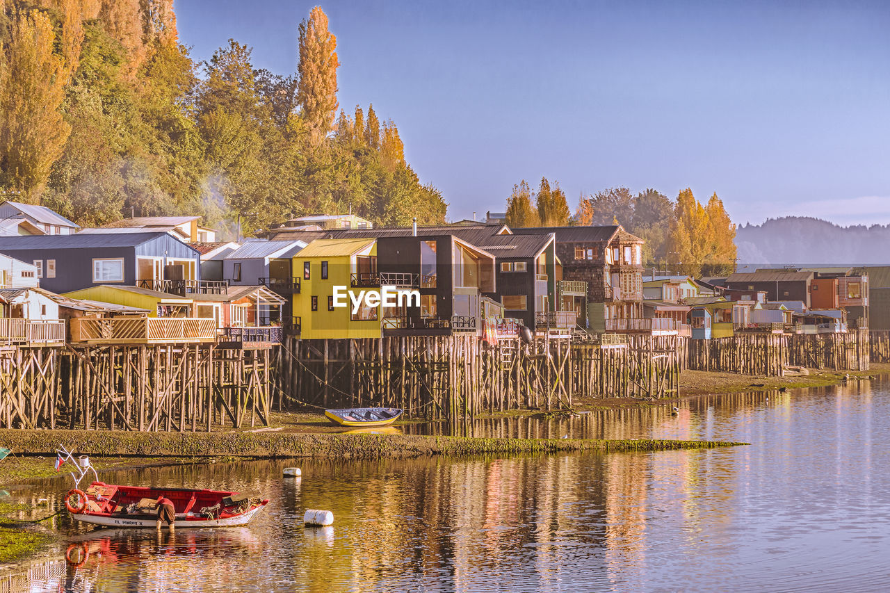 BUILT STRUCTURE BY LAKE AGAINST BUILDINGS