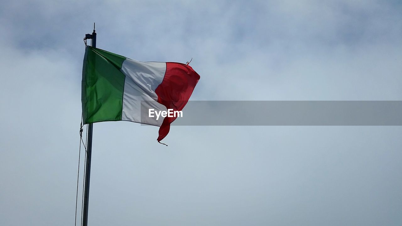 Low angle view of italian flag waving against sky