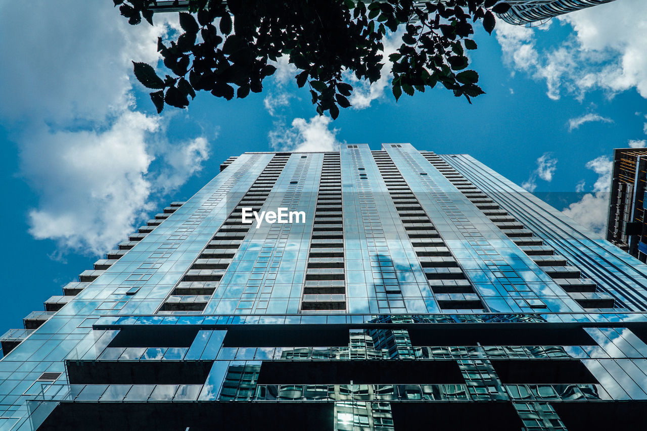 LOW ANGLE VIEW OF MODERN BUILDING AGAINST CLOUDY SKY