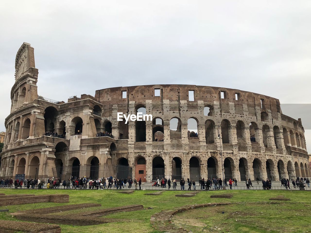 Tourists at amphitheater against sky