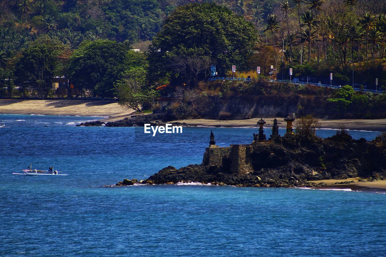 Scenic view of sea against trees