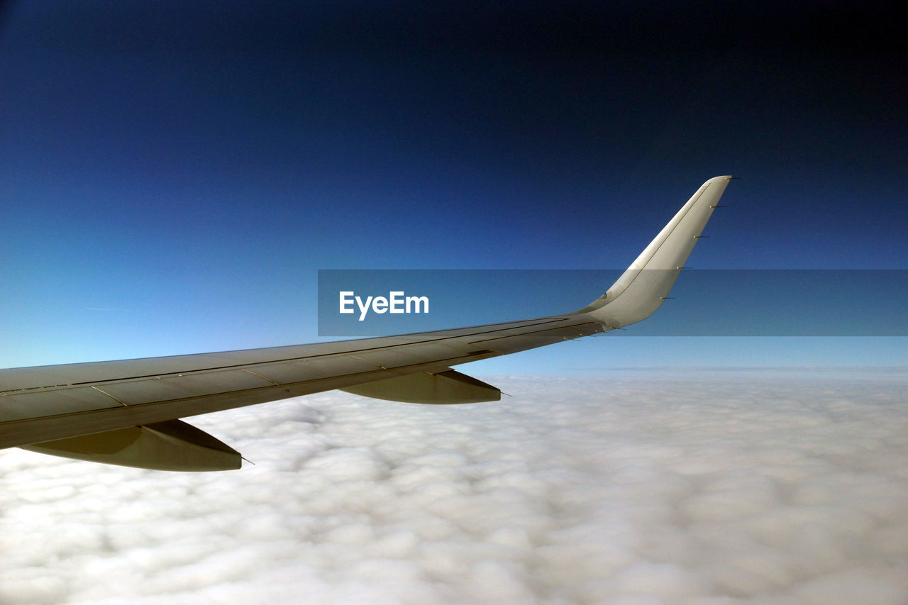 AIRPLANE FLYING AGAINST BLUE SKY