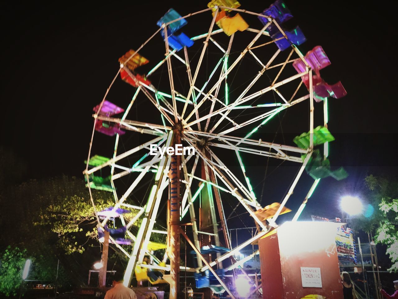 LOW ANGLE VIEW OF ILLUMINATED FERRIS WHEEL AT NIGHT