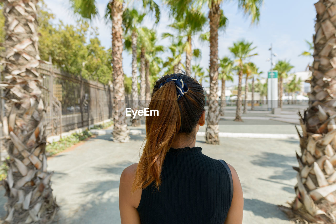 Rear view of woman against trees